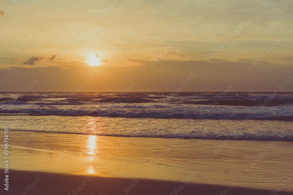 Puesta de Sol en una playa con pequeñas olas