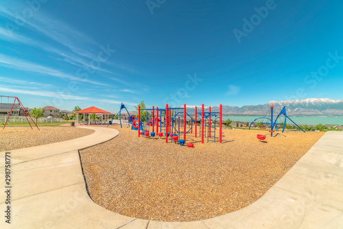 Playground and pavilion at a park with lake and snow capped mountain bakcground