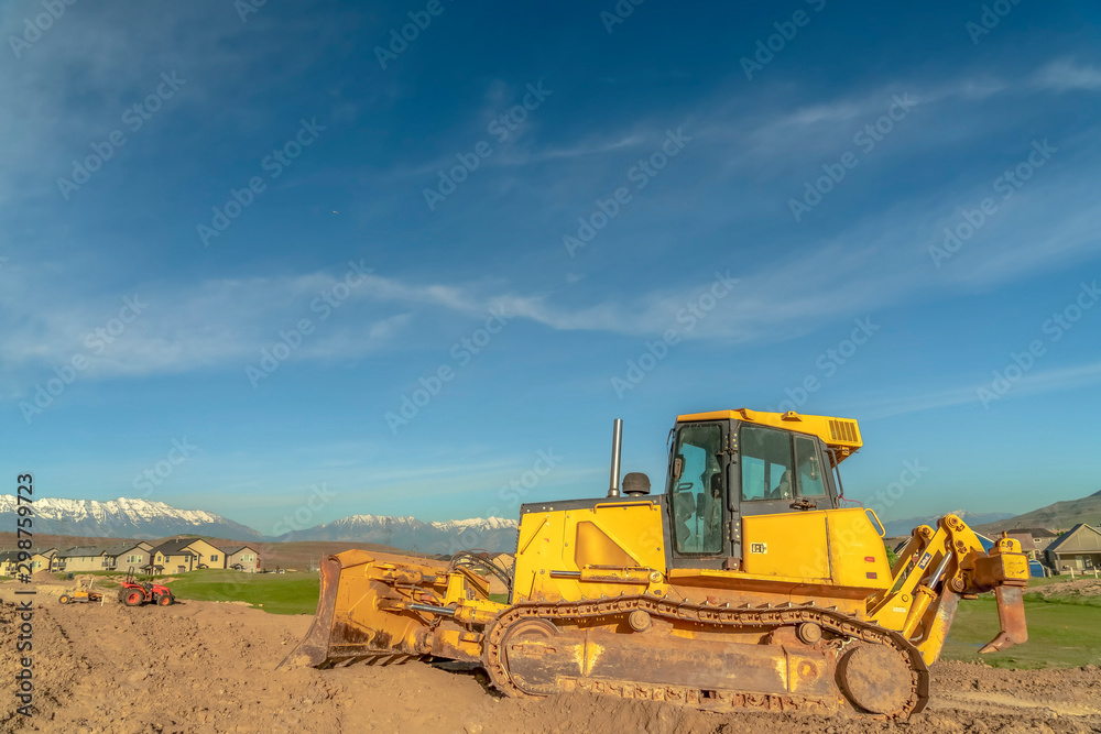 Yellow bulldozer with tracks and a blade used for pushing construction materials Yellow bulldozer with tracks and a blade used for pushing construction materials