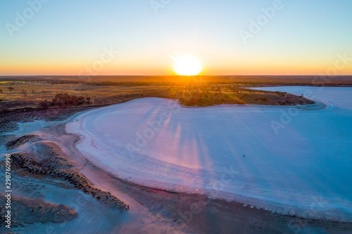 Sunset over salt lake with tiny person on bicycle photo