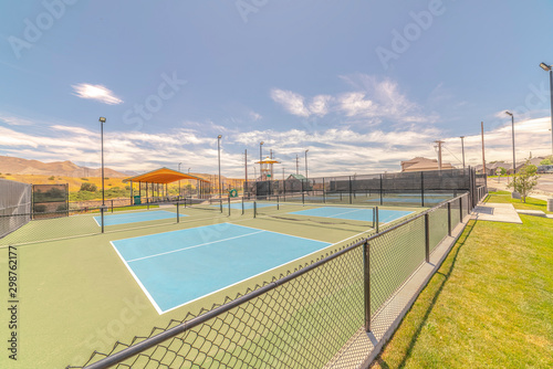 Outdoor tennis courts and sunny recreational park © Jason