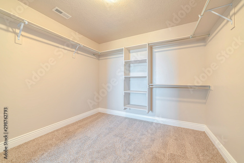 Interior of walk in closet with bare shelving