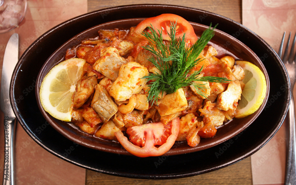 Chicken meal with vegetables in the guvec (Turkish cuisine) on the restaurant table Chicken meal with vegetables in the guvec (Turkish cuisine) on the restaurant table