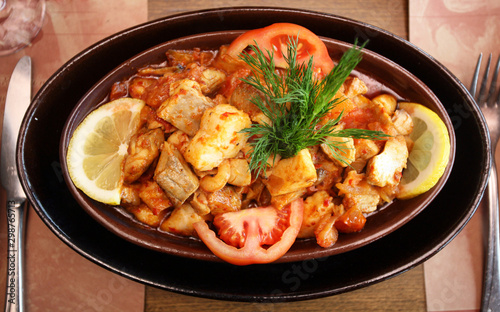 Chicken meal with vegetables in the guvec (Turkish cuisine) on the restaurant table