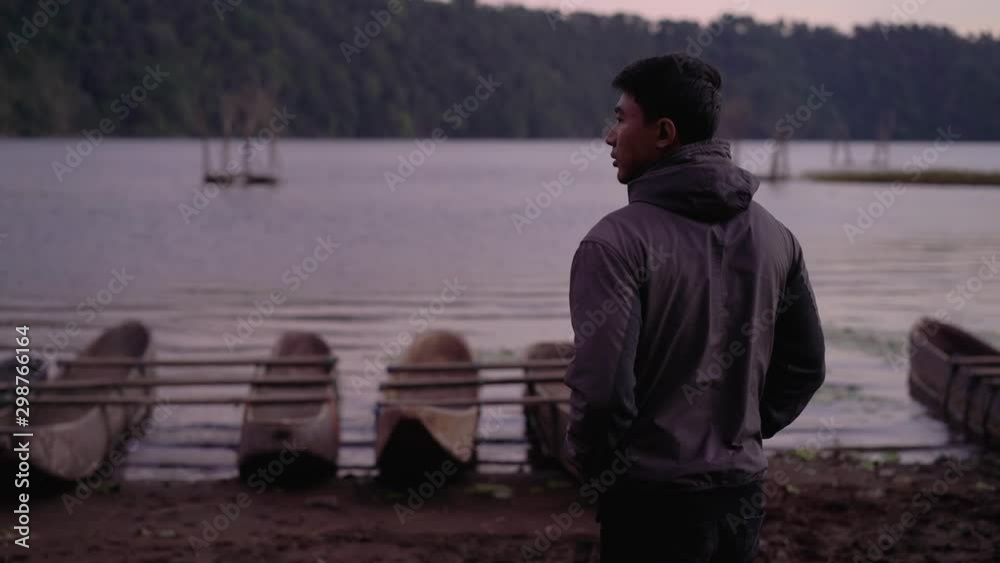portrait of asian young man enjoying the cold morning in countryside near a lake
