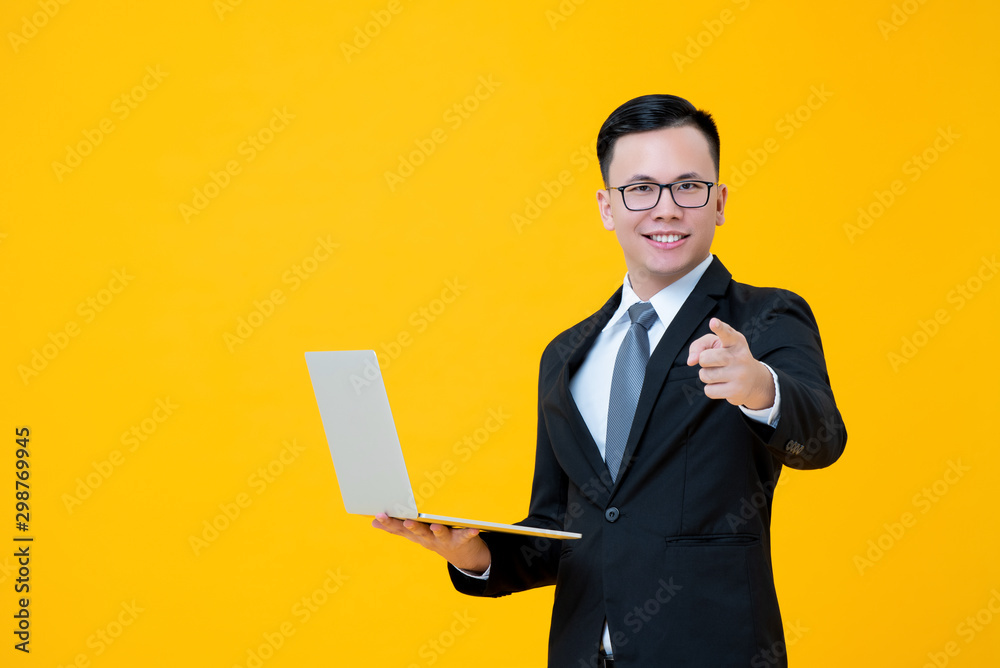 Businessman being happy with online business carrying laptop and pointing finger at you Businessman being happy with online business carrying laptop and pointing finger at you