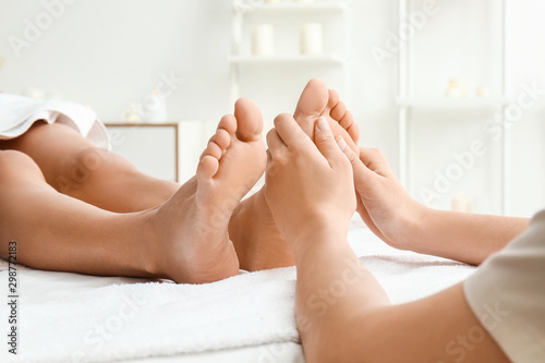 Young woman having feet massage in spa salon