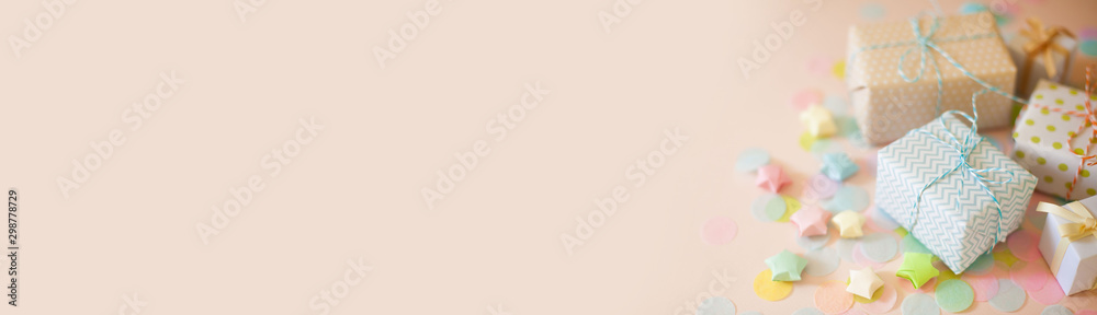 Gift boxes in pastel color. Pink long background.