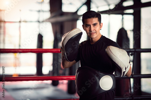 Asian kickboxing trainer in boxing gym © anekoho
