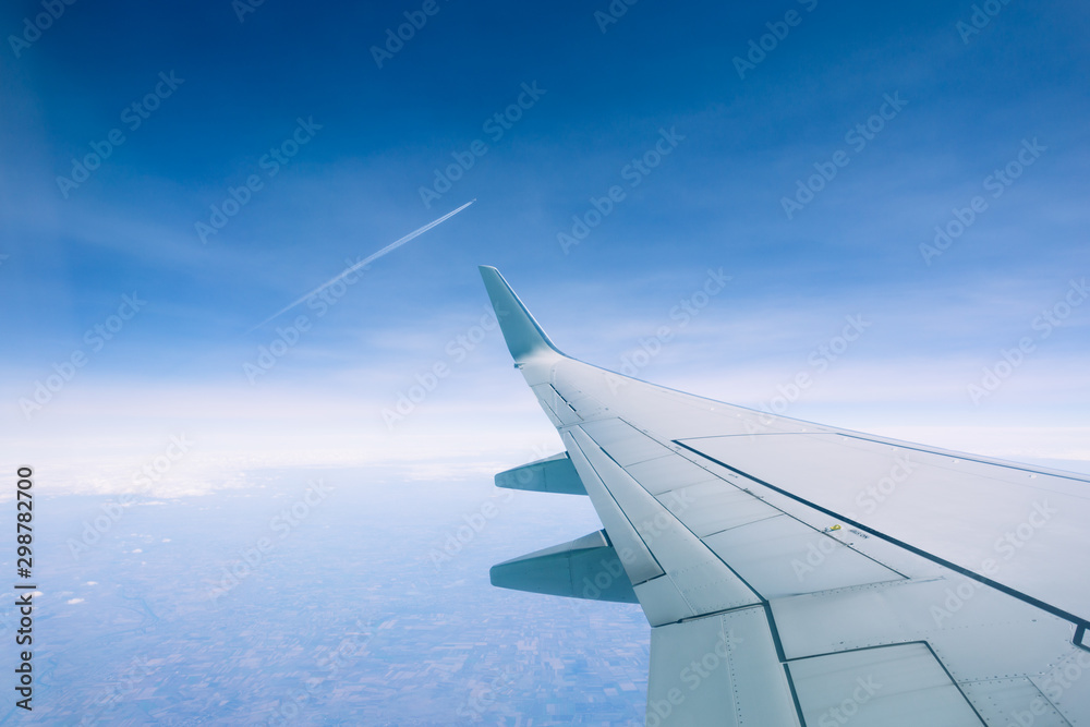 Wing of an airplane flying above the clouds