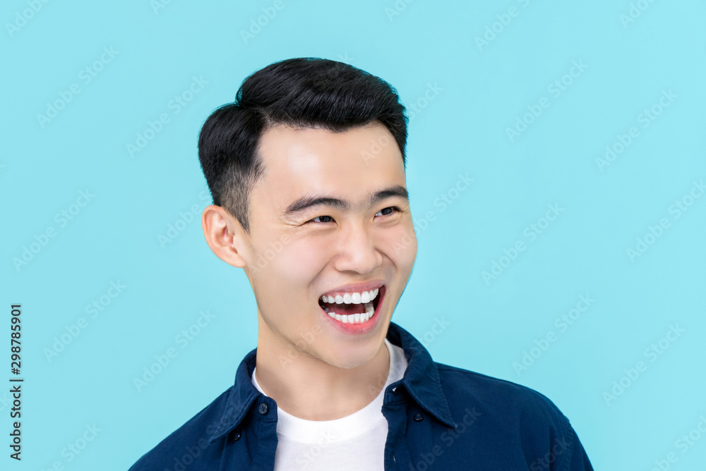 Asian man in plain casual clothes laughing and smiling Asian man in plain casual clothes laughing and smiling