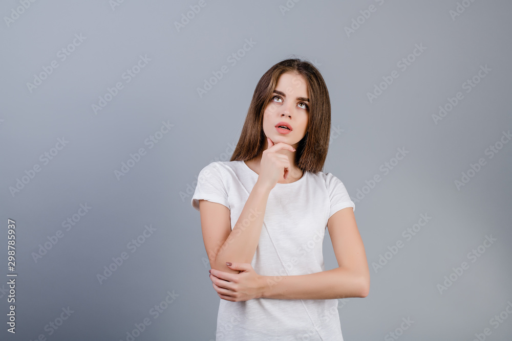 concentrated brunette woman thinking looking at copyspace isolated over grey concentrated brunette woman thinking looking at copyspace isolated over grey