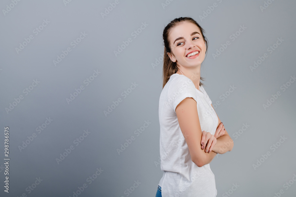 happy beautiful brunette woman with copyspace on her left isolated over grey happy beautiful brunette woman with copyspace on her left isolated over grey
