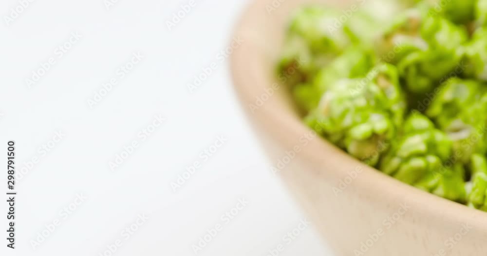 Truck shot of Japanese matcha green tea popcorn in the wooden bowl bulk isolated on white background Truck shot of Japanese matcha green tea popcorn in the wooden bowl bulk isolated on white background