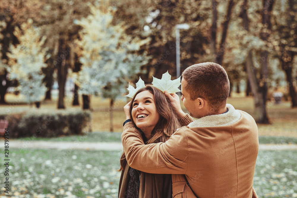 Happy smiling romantic people have fun with maple leaf at autumn park. Happy smiling romantic people have fun with maple leaf at autumn park.