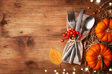 Serving for Thanksgiving dinner with napkin, cutlery and pumpkins top view. Autumn table setting.