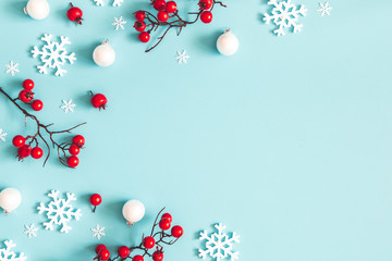 Christmas or winter composition. Snowflakes and red berries on blue background. Christmas, winter, new year concept. Flat lay, top view, copy space