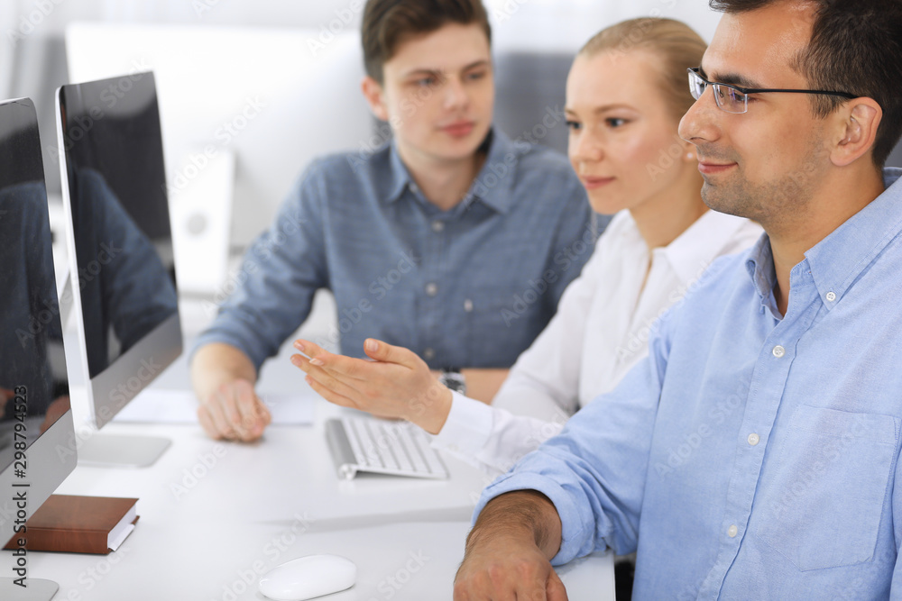 Fototapeta premium Business people working together in modern office. Focus at happy smiling adult businessman or entrepreneur using pc computer. Teamwork and partnership concept. Casual dress style