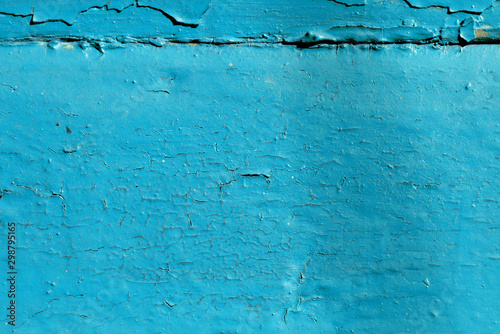 Blue color old painted wooden wall lit by sun close-up. Abstract background