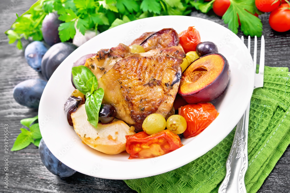 Chicken with fruits and tomatoes in plate on table Chicken with fruits and tomatoes in plate on table