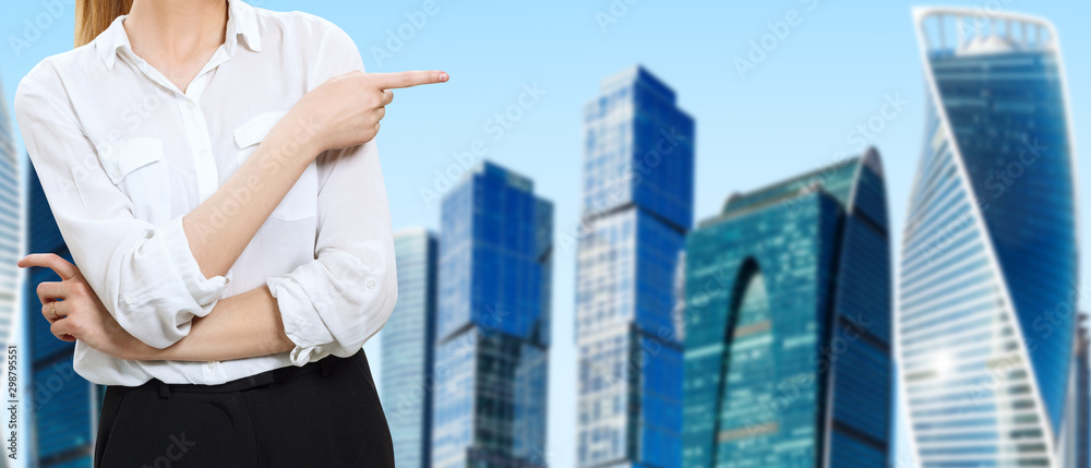 Business woman in white blouse stands over cityscape background.