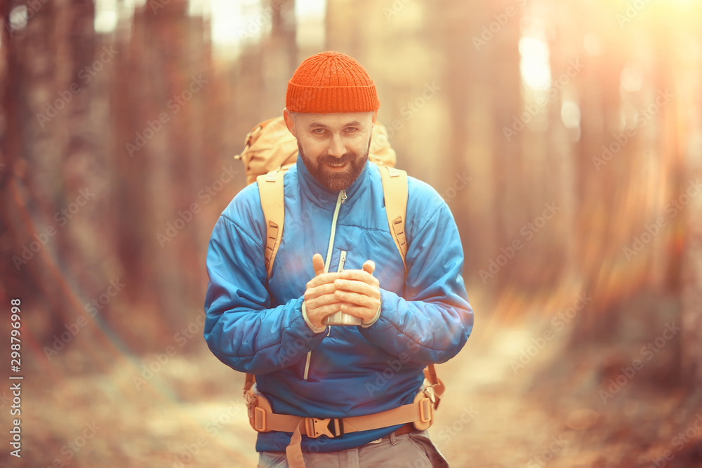 Obraz premium hot drink on the hike, a man drinks hot on the hike, adventure forest October