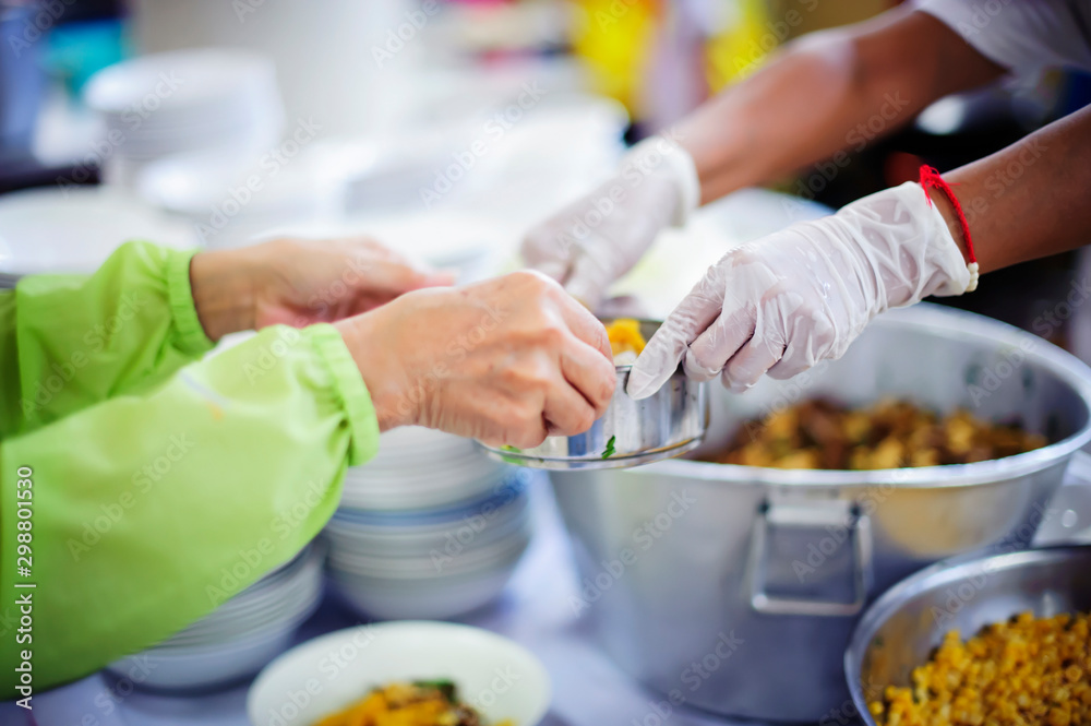 Volunteers are donating free charity food to homeless beggars: the concept of food needs in society. Volunteers are donating free charity food to homeless beggars: the concept of food needs in society.