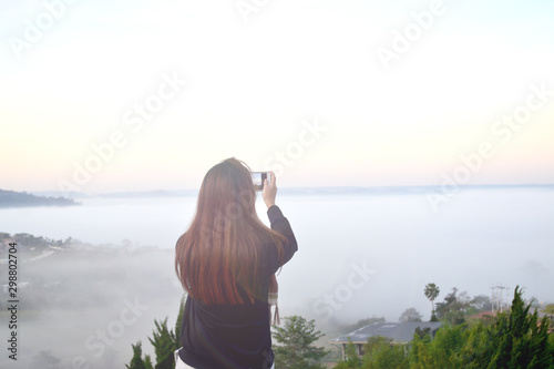 Tourists take pictures of mist on the mountain