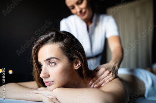 Masseur doing massage on female body in the spa salon. Beauty treatment concept.