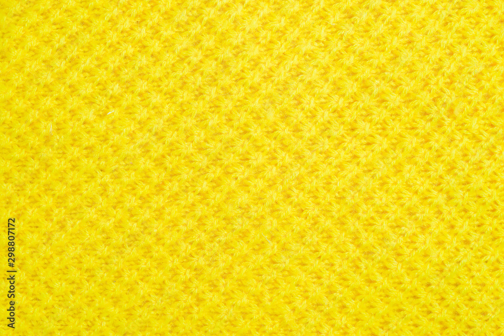 The tail is made of yellow knitted fabric texture. knitting texture close up Photo. orange, yellow knitted background. the texture of the warm fabric. colorful bright wool