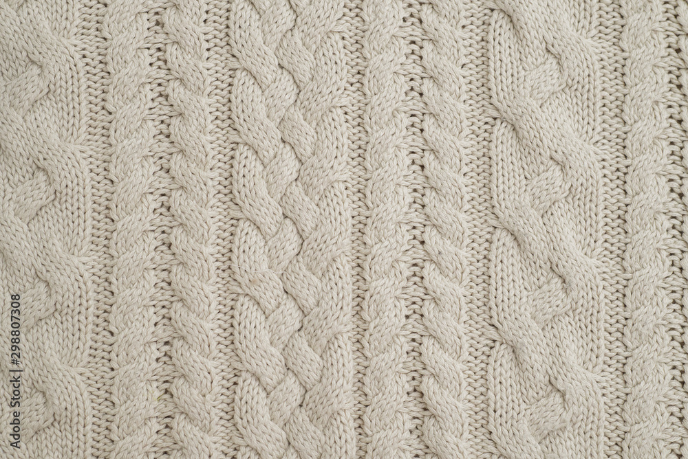 The tail is made of beige knitted fabric texture. Machine knitting texture close up Photo. Beige grey knitted background. the texture of the warm fabric