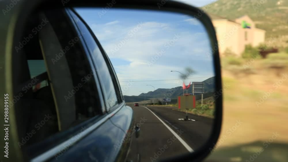 Closeup on a rear-view mirror while driving through the desert. Closeup on a rear-view mirror while driving through the desert.