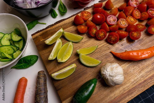 Close up of a cutting board with  a selection of healthy vegetables and fruit on a wooden cutting board