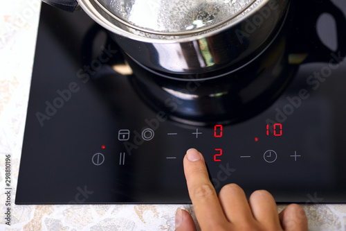 Woman hand includes modern induction stove photo