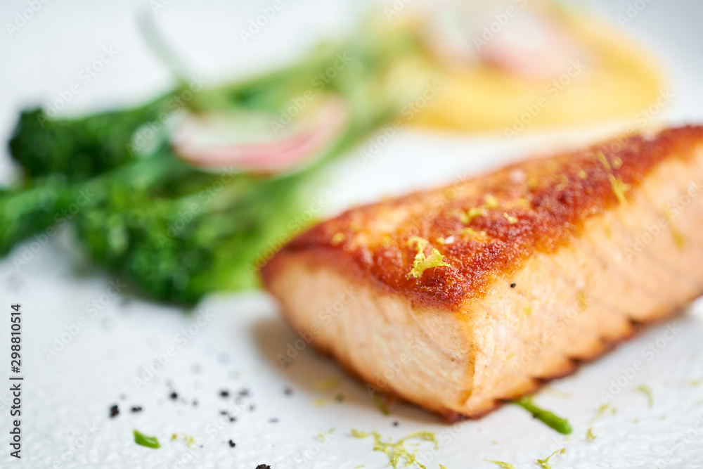 Salmon steak fillet and garnished with young broccoli. Restaurant menu, a series of photos of different dishes Salmon steak fillet and garnished with young broccoli. Restaurant menu, a series of photos of different dishes