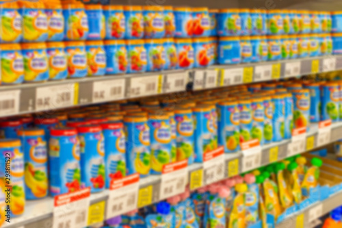 Defocused background  baby food supermarket shelves  fruit puree and porridge for feeding small children  blurred backdrop