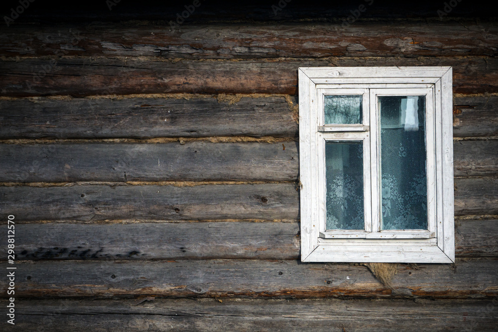 Old window in a country house. The texture of the logs. Rustic background.