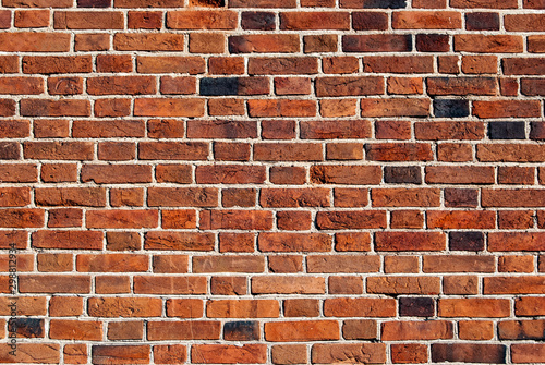 The background of the brick wall, made of bricks of dark orange color. Can be used for interior design.