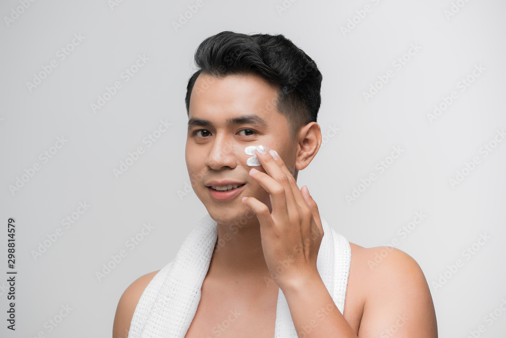 smiling man applying cosmetic cream on face, smiling man applying cosmetic cream on face,