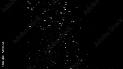 Blurry images of soda water bubbles splashing and floating up to top of water surface which little and big circle texture shaped up by gas power in carbonate drink make refreshing moment on black