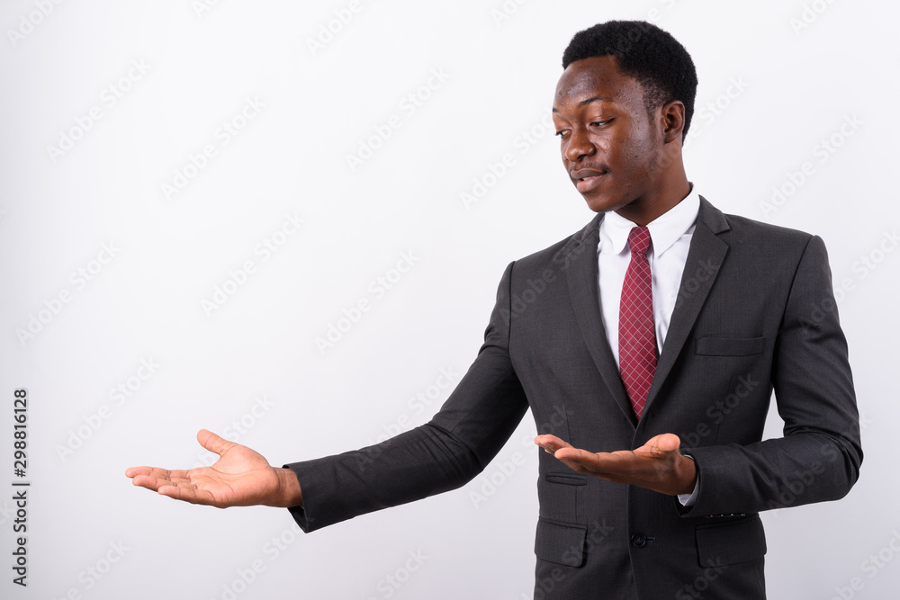 Young handsome African businessman wearing suit against white ba Young handsome African businessman wearing suit against white ba