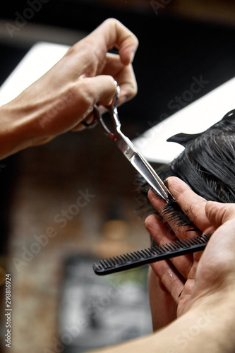 a man cuts his hair with scissors close-up