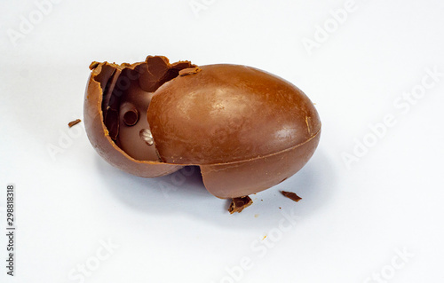 Chocolate egg. A broken, exploded eggshell, two halves, and a whole chicken egg. A sweet symbol of Easter,a dessert of dark cocoa, the design of the celebration. © Сергей Семенов