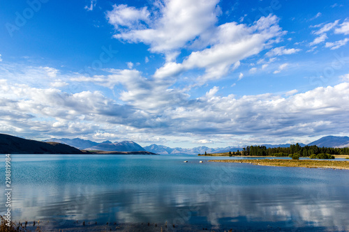 Beautiful Lake Tekapo with mountain range in the Background on a sunny day with withe clouds  South Island  New Zealand