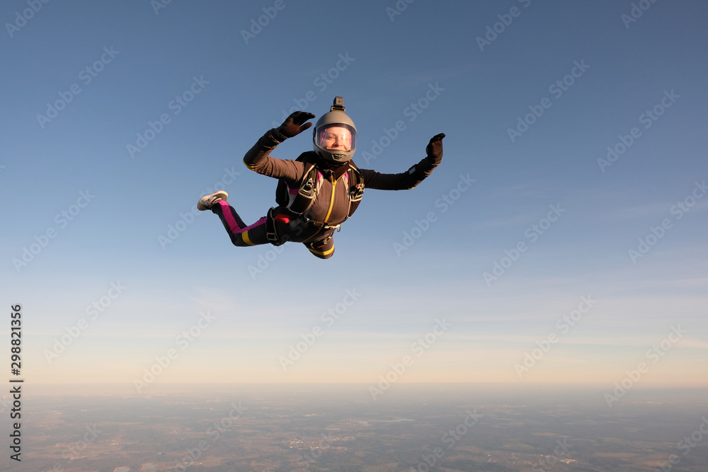 Skydiving. An active woman is flying in the sky.