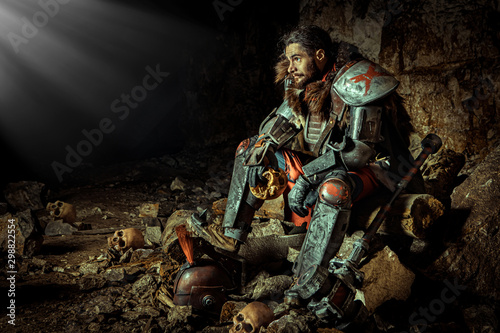 Принти на полотні Powerful knight in the armor with the hammer is sitting on the stone