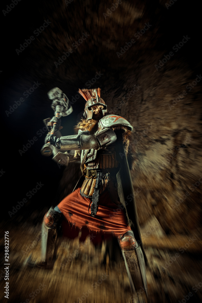 Fototapeta premium Attack of a powerful knight in the armor with the hammer. Dungeon on the background.