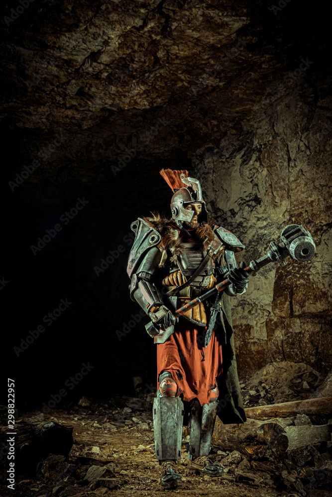 Powerful knight in the armor with the hammer. Dungeon on the background. Powerful knight in the armor with the hammer. Dungeon on the background.