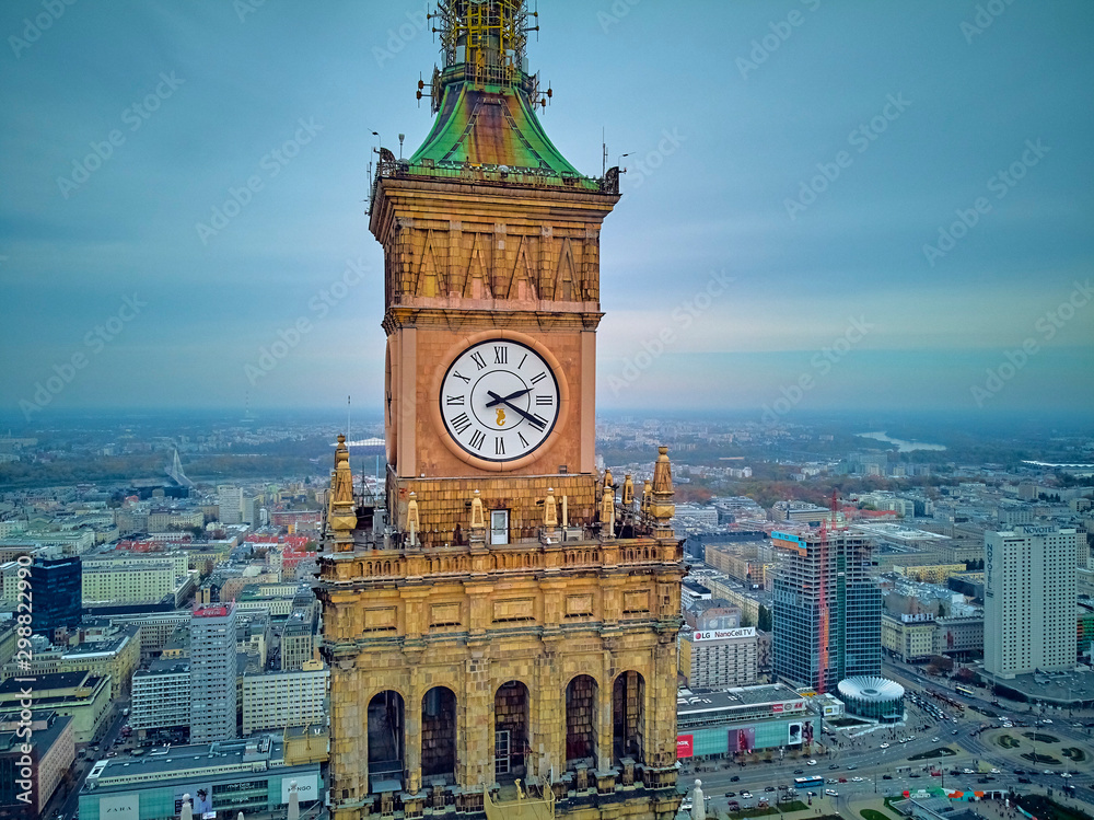 Fototapeta premium Beautiful panoramic aerial close-up drone view to the Millennium clock (clock face diameter = 6.5 m) on the tower of PKiN and cityscape of Warsaw modern City, Poland