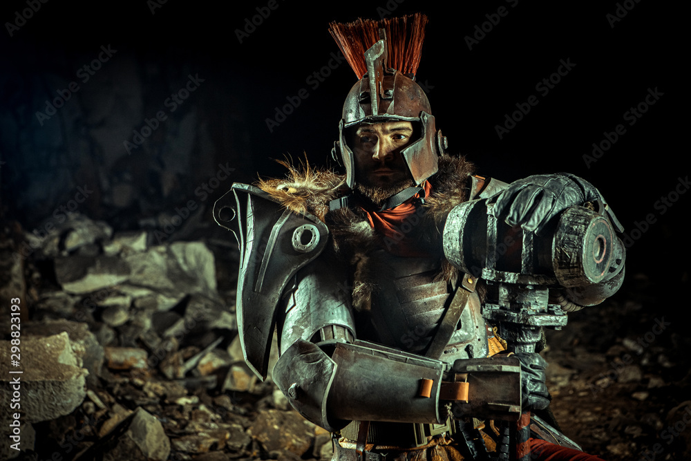 Powerful knight in the armor with the hammer. Dungeon on the background. Powerful knight in the armor with the hammer. Dungeon on the background.